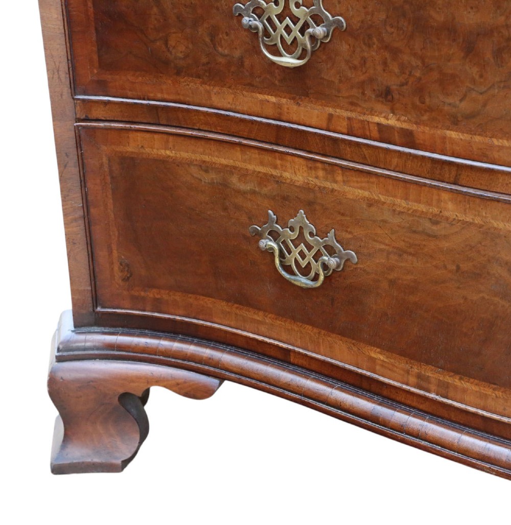 A serpentine-front burr walnut chest of drawers featuring crossbanded borders, cast brass handles, and ogee bracket feet. View VI
