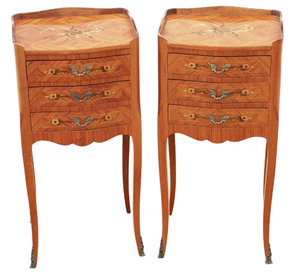 A pair of slim French style bedside tables featuring floral marquetry wood inlays, three drawers with brass handles, and slender cabriole legs.