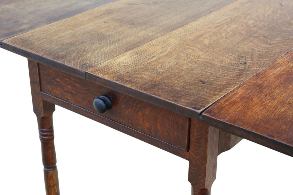 A Georgian oak drop-leaf Pembroke table featuring turned legs, a single end drawer, and brass castors. View III