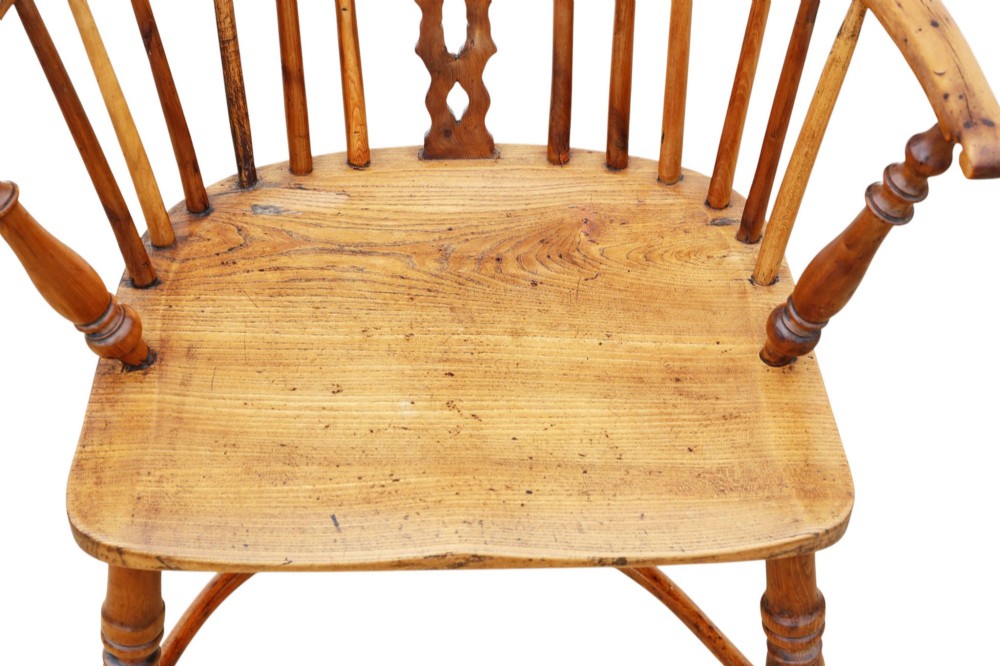 A nineteenth-century wooden Windsor armchair featuring a curved hoop back, a decorative central splat, shaped elm seat, and turned legs with a crinoline stretcher. View V