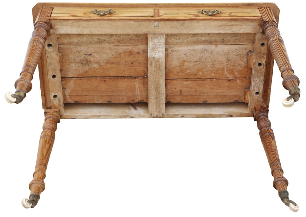 A 19th-century pitch pine writing table with two drawers, brass handles, turned legs, and metal castors. View VIII
