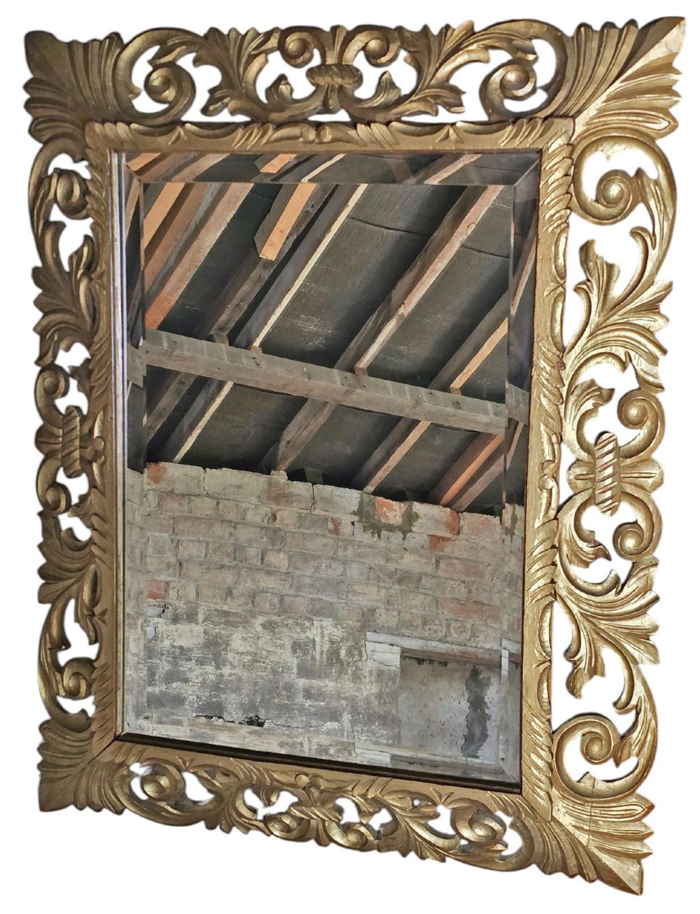 A rectangular bevelled glass mirror set within an intricately carved gold giltwood frame with openwork acanthus leaves and scrollwork. View II