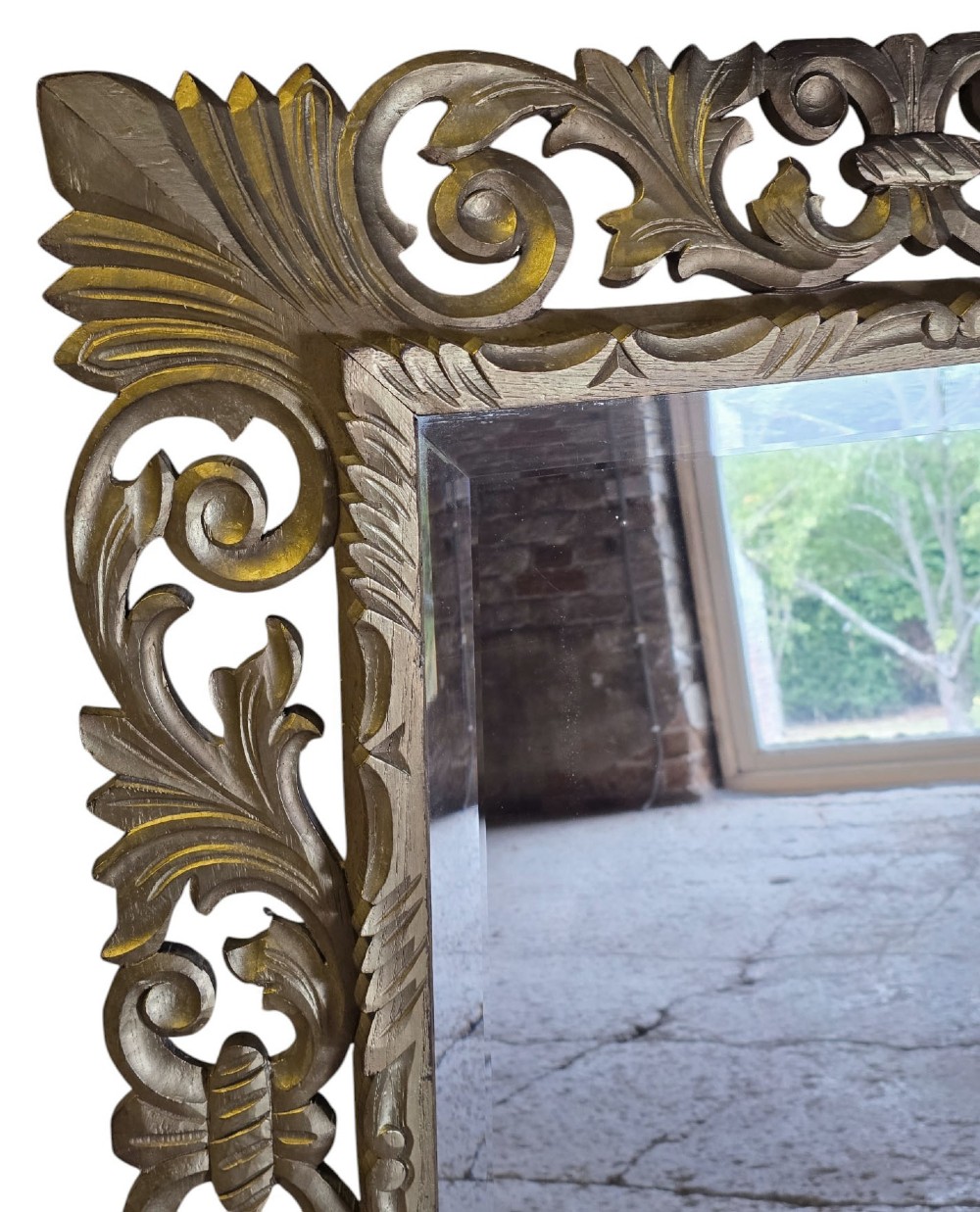 A rectangular bevelled glass mirror set within an intricately carved gold giltwood frame with openwork acanthus leaves and scrollwork. View III