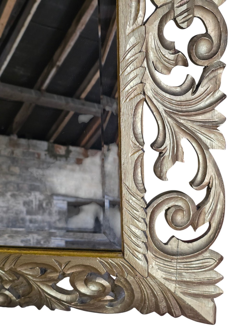 A rectangular bevelled glass mirror set within an intricately carved gold giltwood frame with openwork acanthus leaves and scrollwork. View V