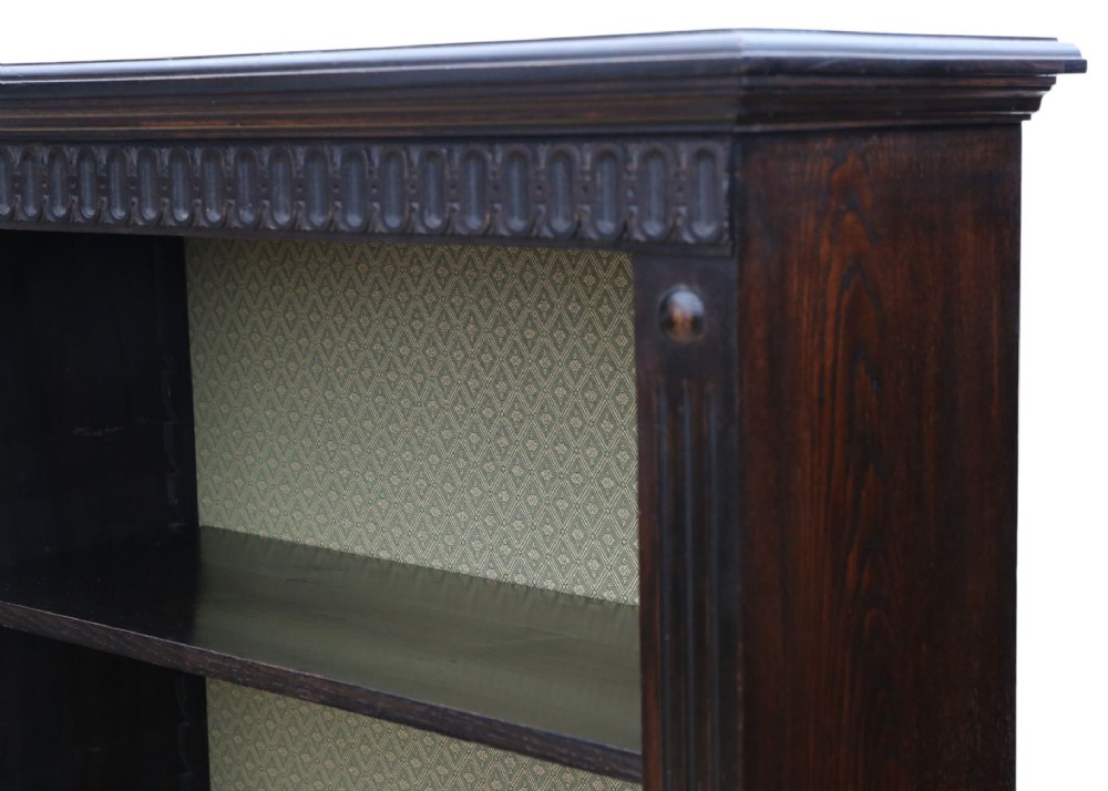 A matching pair of dark oak double-bay bookcases featuring fluted vertical trim, adjustable shelving, green pattern-lined interiors, and bracket bases. View IV