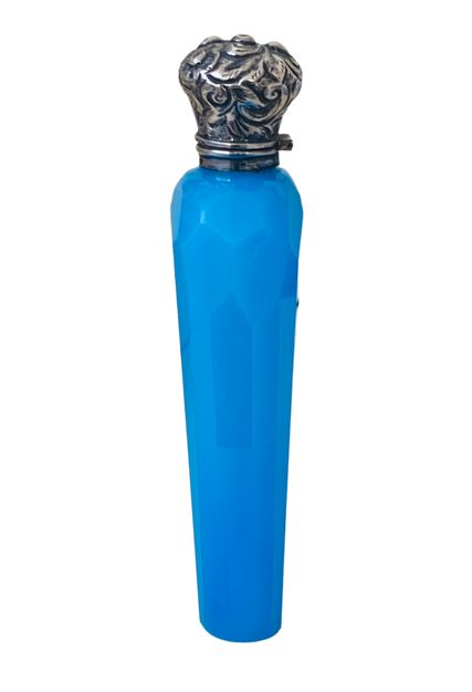 fig 1. A vibrant blue faceted opaline glass scent bottle topped with an ornate repousse silver cap.