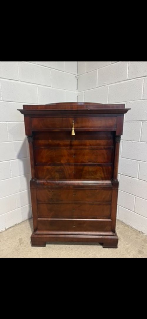 A 19th-century Biedermeier flame mahogany secretaire chest featuring a fall-front desk section, side column supports, and multiple storage drawers. View II