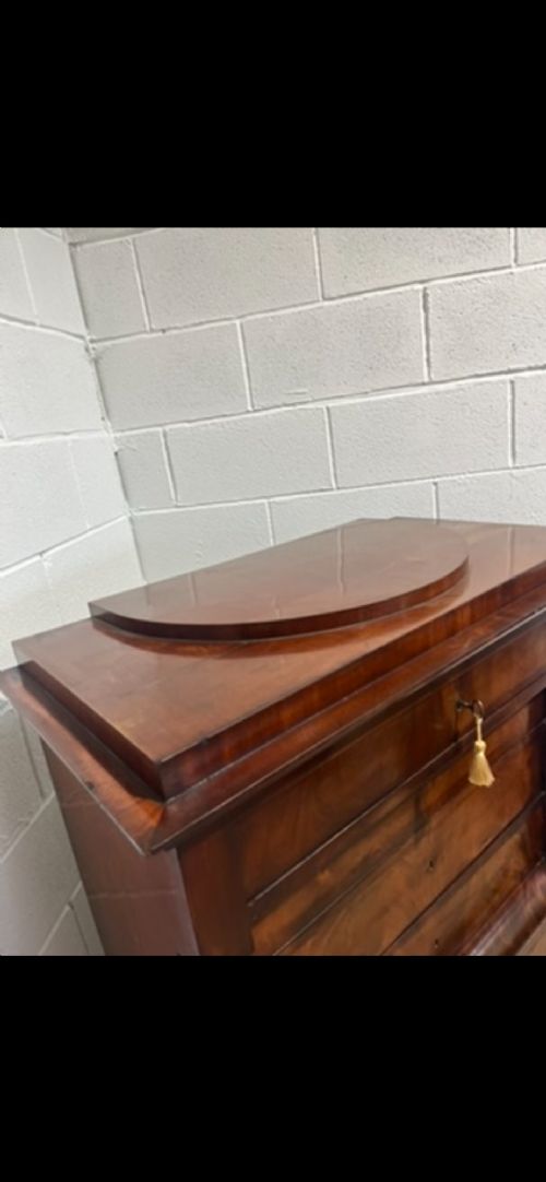 A 19th-century Biedermeier flame mahogany secretaire chest featuring a fall-front desk section, side column supports, and multiple storage drawers. View V