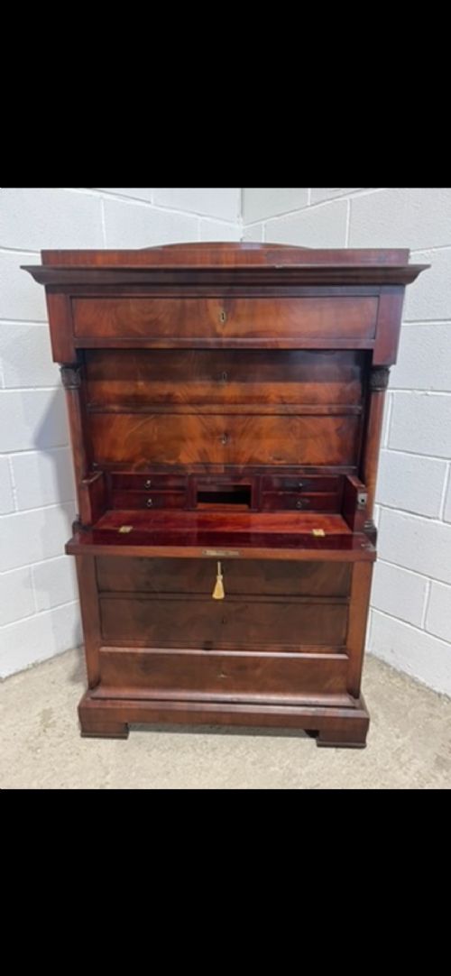 A 19th-century Biedermeier flame mahogany secretaire chest featuring a fall-front desk section, side column supports, and multiple storage drawers. View VIII