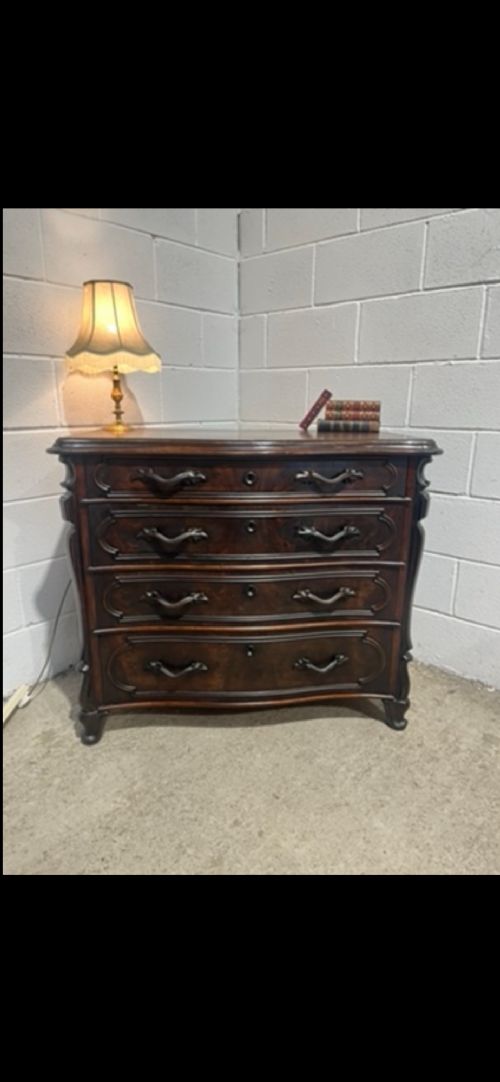 A 19th-century dark walnut French chest of drawers featuring a serpentine front, four moulded drawers, and dark metal handles. View II