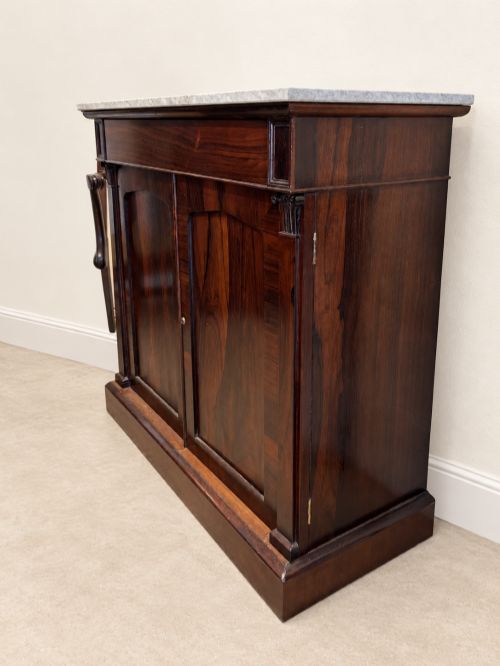 fig 1. A pair of 19th-century Regency dark rosewood cupboards featuring white marble tops and panelled double doors on plinth bases.