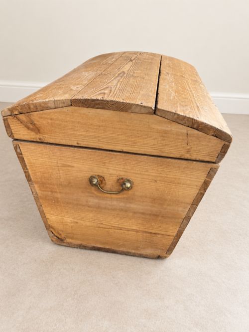 fig 1. A nineteenth-century pine trunk featuring a curved lid, visible dovetail corner joints, a brass keyhole escutcheon, and brass side handles.