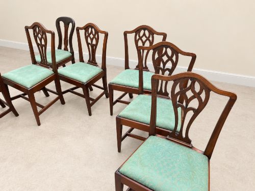 fig 1. A set of six Georgian mahogany dining chairs featuring openwork pierced back splats, serpentine top rails, square legs with H-stretchers, and green patterned upholstered seats.