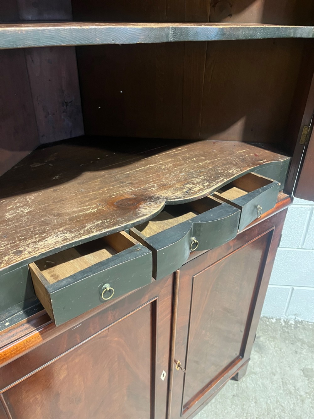 A tall Georgian floor-standing corner cupboard made of dark flame mahogany, featuring two upper doors and two lower doors with brass diamond escutcheons. View IX