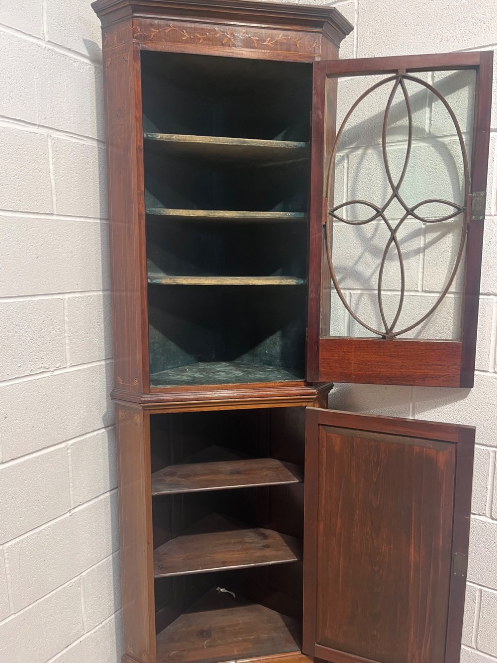 A 19th-century floor-standing mahogany corner cupboard featuring a glazed upper door with oval astragal glazing and an inlaid lower cabinet door. View IX