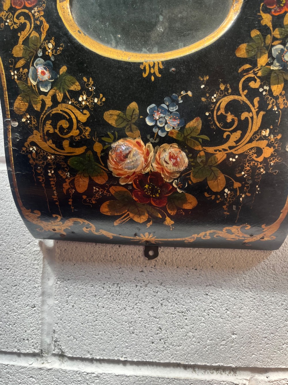 A 19th-century Victorian wall clock featuring a scalloped ebonised case decorated with gilt scrollwork and polychrome floral painting around a cream dial with Roman numerals. View VI