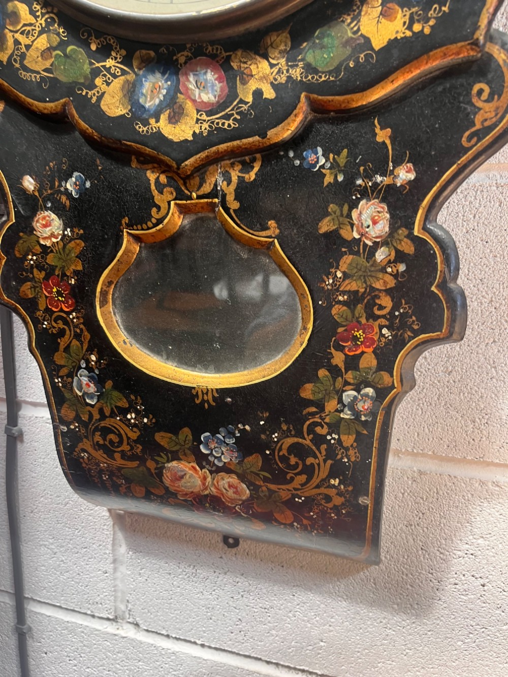 A 19th-century Victorian wall clock featuring a scalloped ebonised case decorated with gilt scrollwork and polychrome floral painting around a cream dial with Roman numerals. View VIII