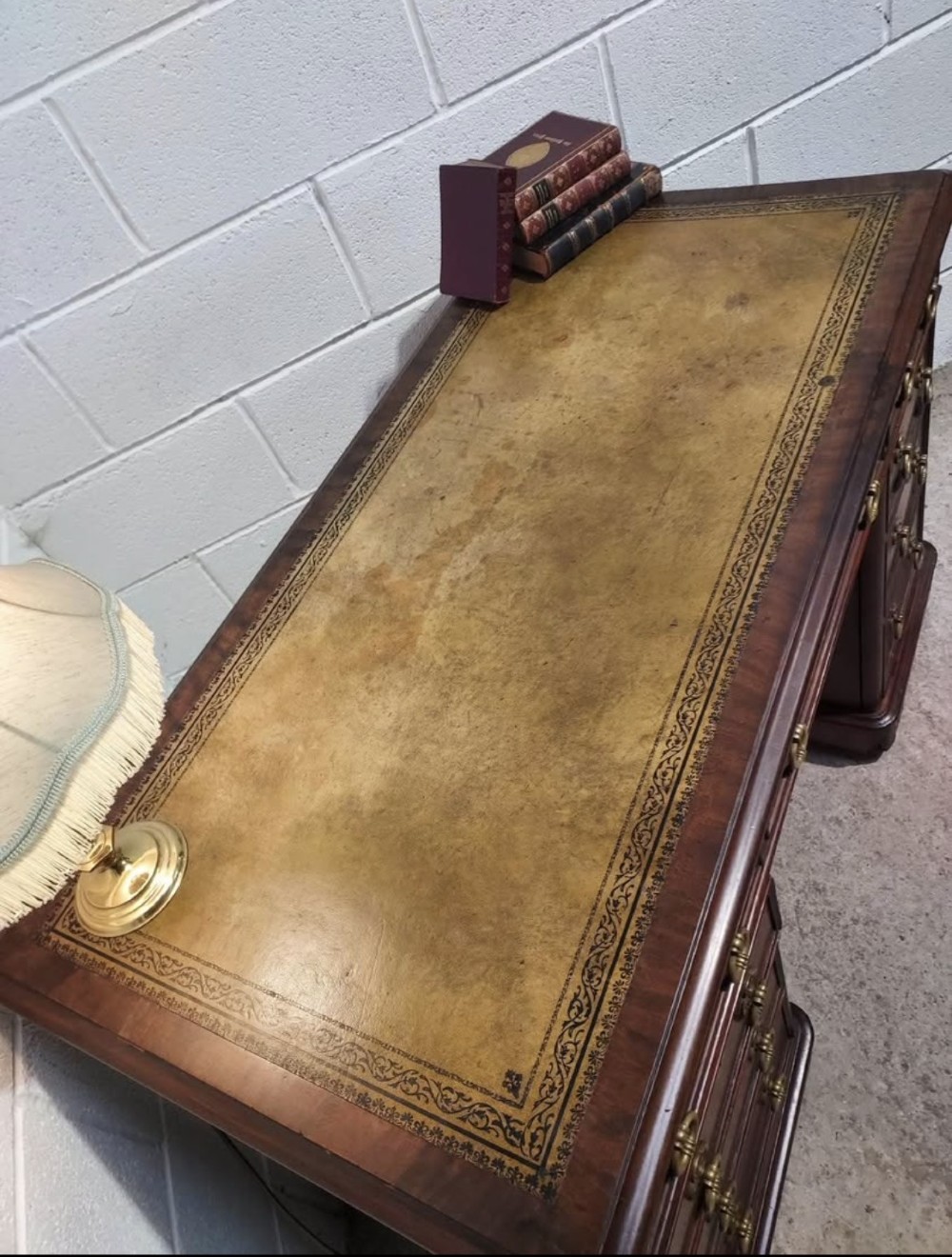 A 19th-century dark mahogany pedestal desk with multiple drawers featuring brass ring handles and a plinth base. View VII