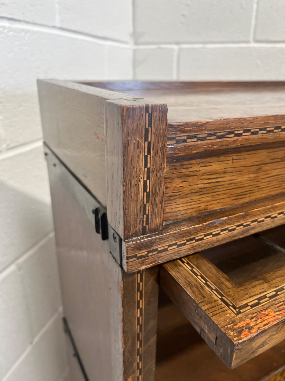 A three-tier oak sectional Globe Wernicke bookcase featuring leaded glass up-and-over doors, inlaid decorative banding, and a single bottom drawer. View XI
