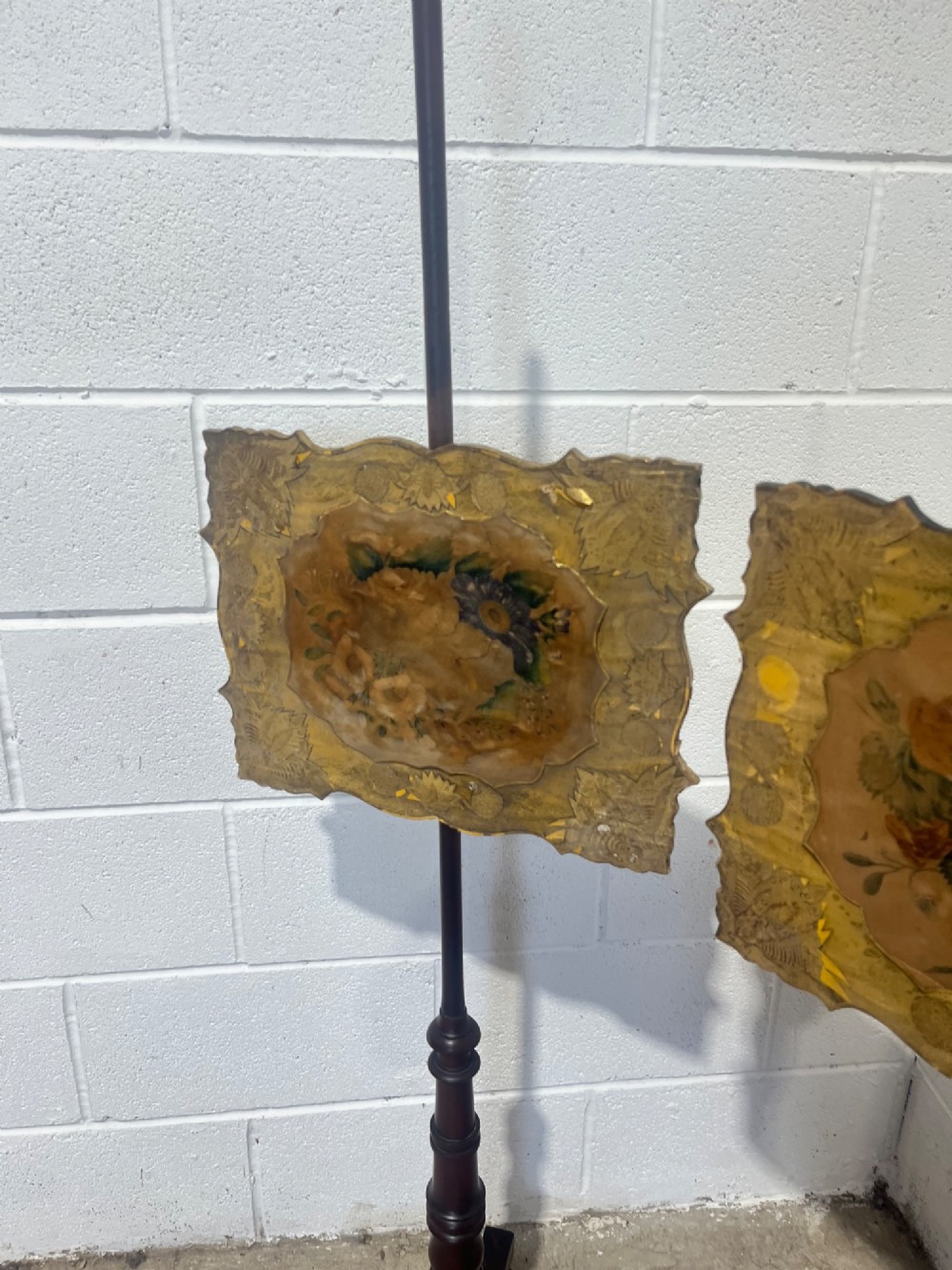 A pair of antique Regency mahogany pole screens with turned central spindles, tripod bases, and rectangular adjustable panels featuring floral paintings surrounded by gilded borders. View VII