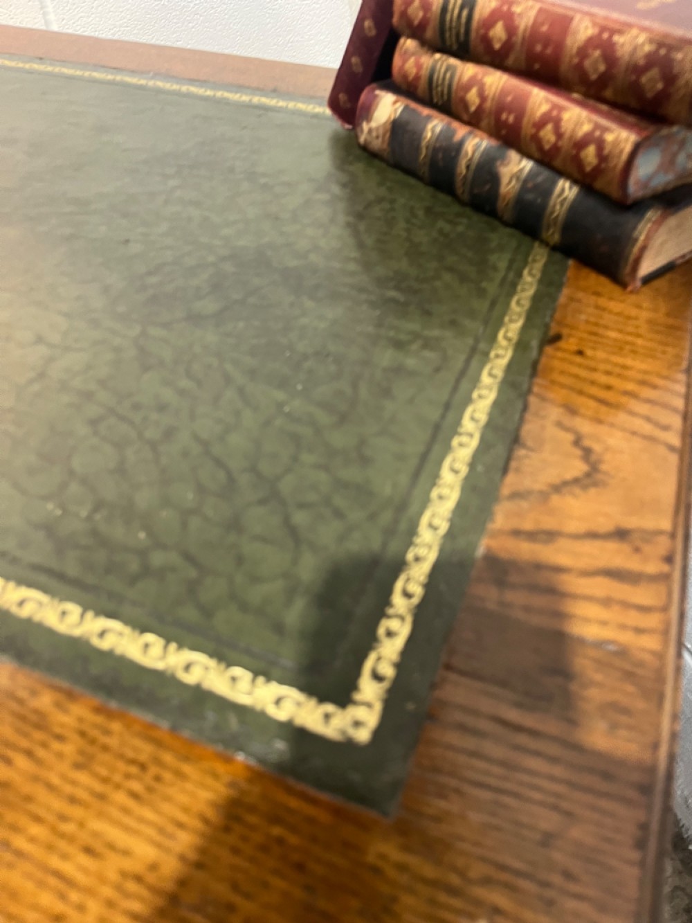 A late 19th-century dark oak freestanding pedestal desk featuring a green leather inset writing surface, nine drawers with brass handles, and plinth bases. View IX