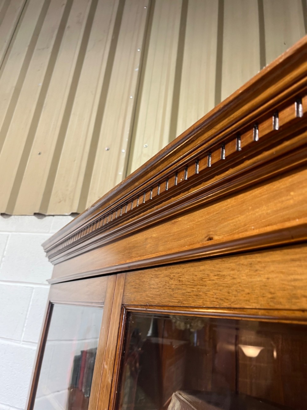A 19th-century mahogany glazed bookcase featuring upper double glass doors filled with books, middle drawers, and lower doors with carved foliate panels. View V