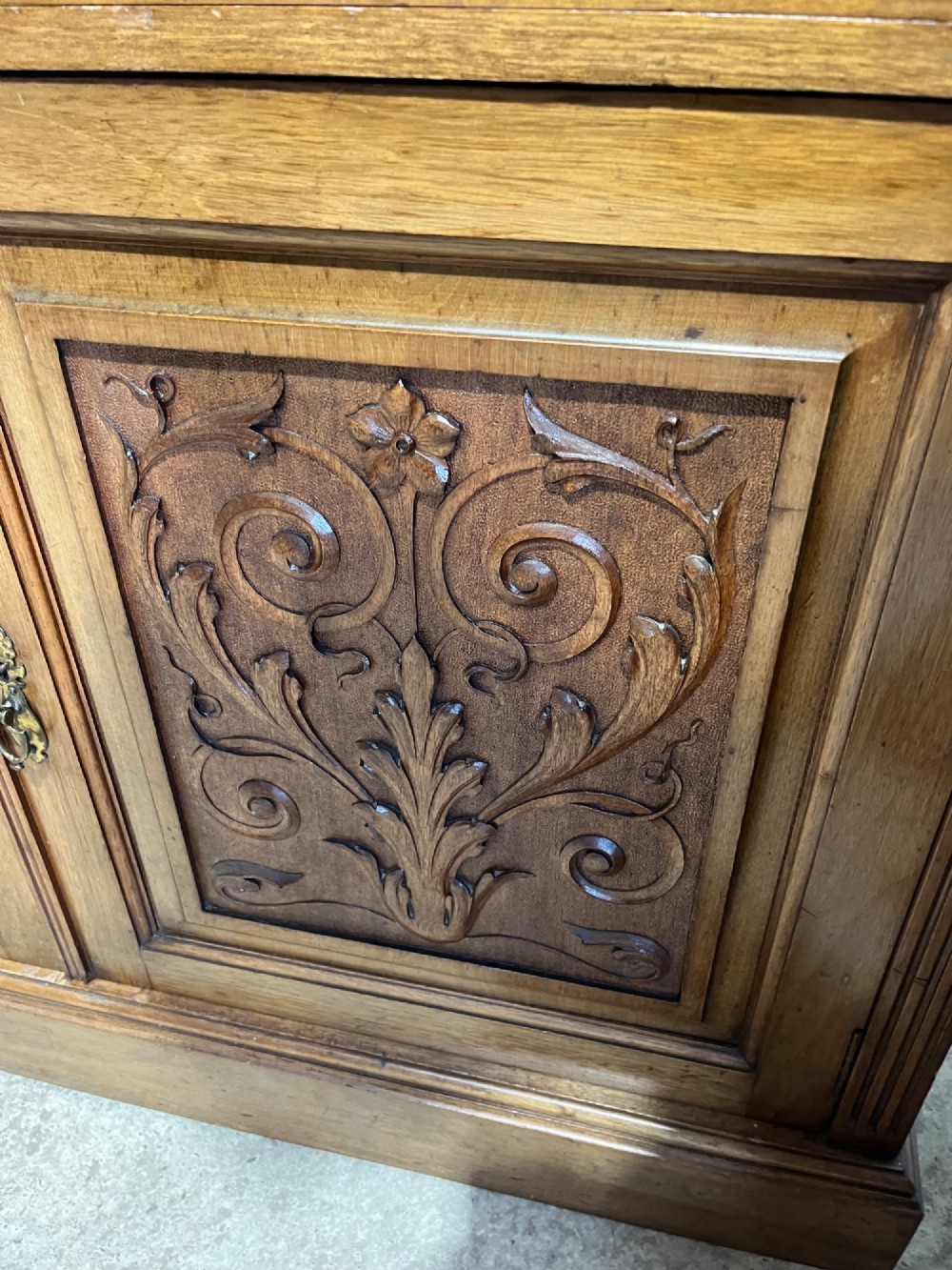 A 19th-century mahogany glazed bookcase featuring upper double glass doors filled with books, middle drawers, and lower doors with carved foliate panels. View VII