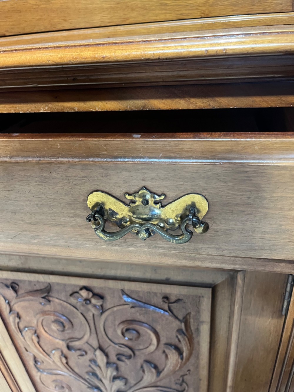 A 19th-century mahogany glazed bookcase featuring upper double glass doors filled with books, middle drawers, and lower doors with carved foliate panels. View X