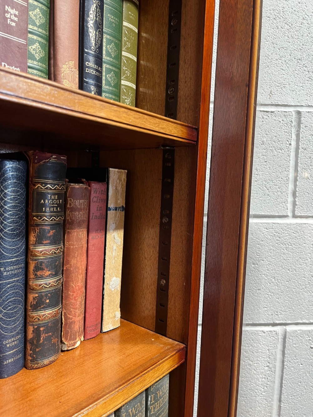 A 19th-century mahogany glazed bookcase featuring upper double glass doors filled with books, middle drawers, and lower doors with carved foliate panels. View XII