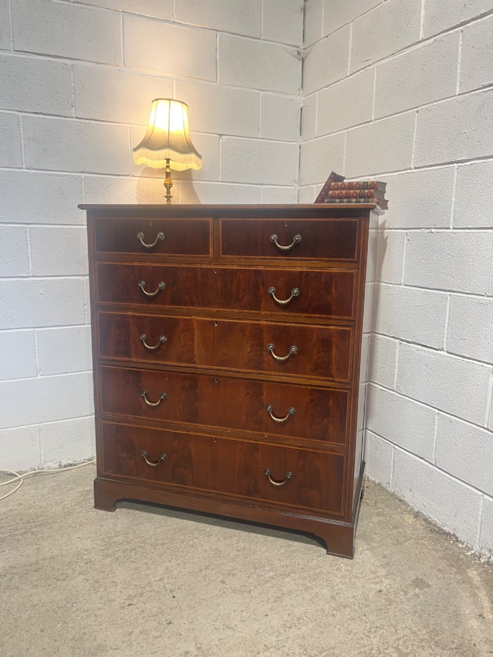 A late 19th-century mahogany chest of drawers featuring two short upper drawers over four long drawers, detailed with satinwood stringing and brass handles. View II