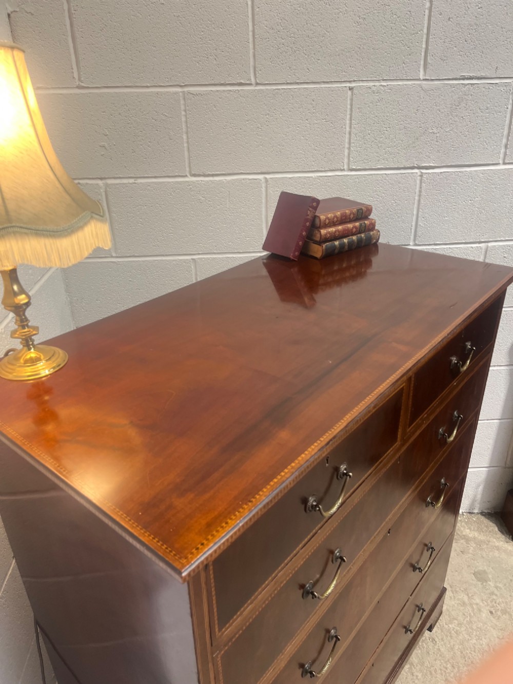A late 19th-century mahogany chest of drawers featuring two short upper drawers over four long drawers, detailed with satinwood stringing and brass handles. View VI