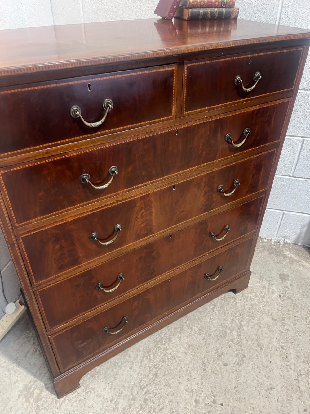 A late 19th-century mahogany chest of drawers featuring two short upper drawers over four long drawers, detailed with satinwood stringing and brass handles. View IX