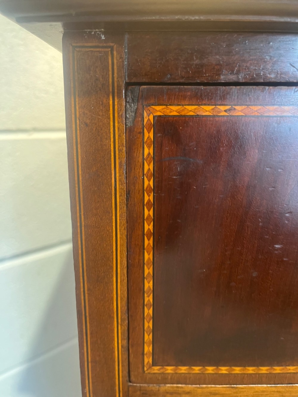 A late 19th-century mahogany chest of drawers featuring two short upper drawers over four long drawers, detailed with satinwood stringing and brass handles. View XI