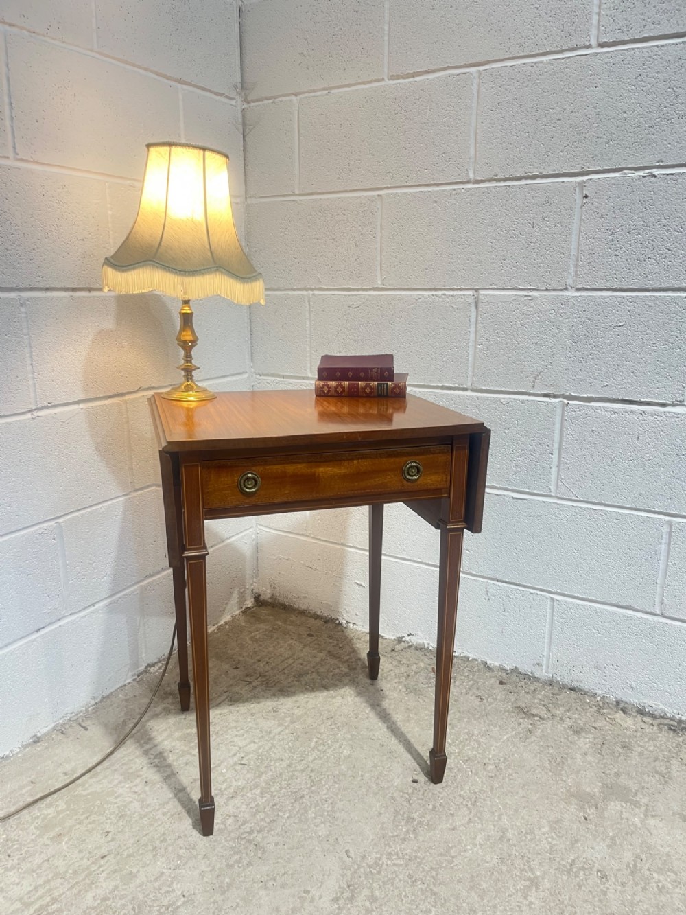 A 19th-century mahogany side table featuring two hinged drop leaves, a single frieze drawer with dual brass ring handles, boxwood line inlay, and four square tapered legs. View II