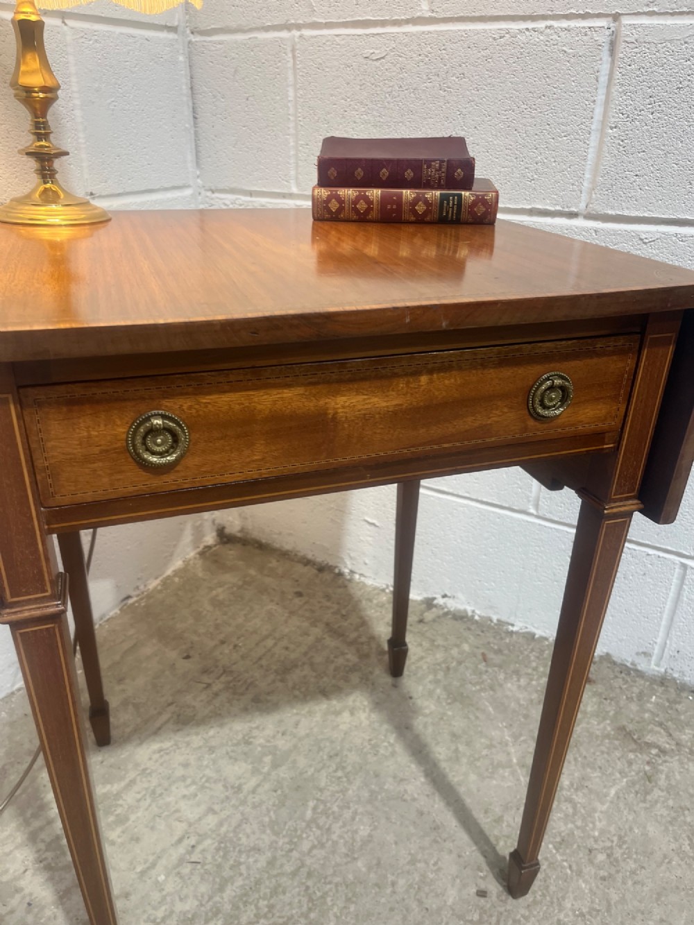 A 19th-century mahogany side table featuring two hinged drop leaves, a single frieze drawer with dual brass ring handles, boxwood line inlay, and four square tapered legs. View IV
