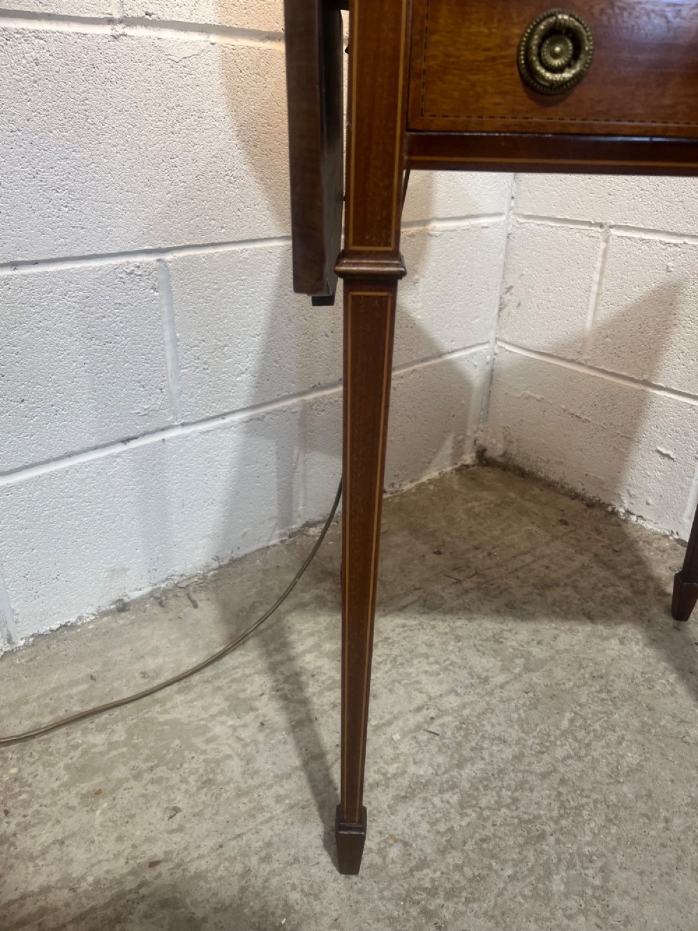A 19th-century mahogany side table featuring two hinged drop leaves, a single frieze drawer with dual brass ring handles, boxwood line inlay, and four square tapered legs. View V