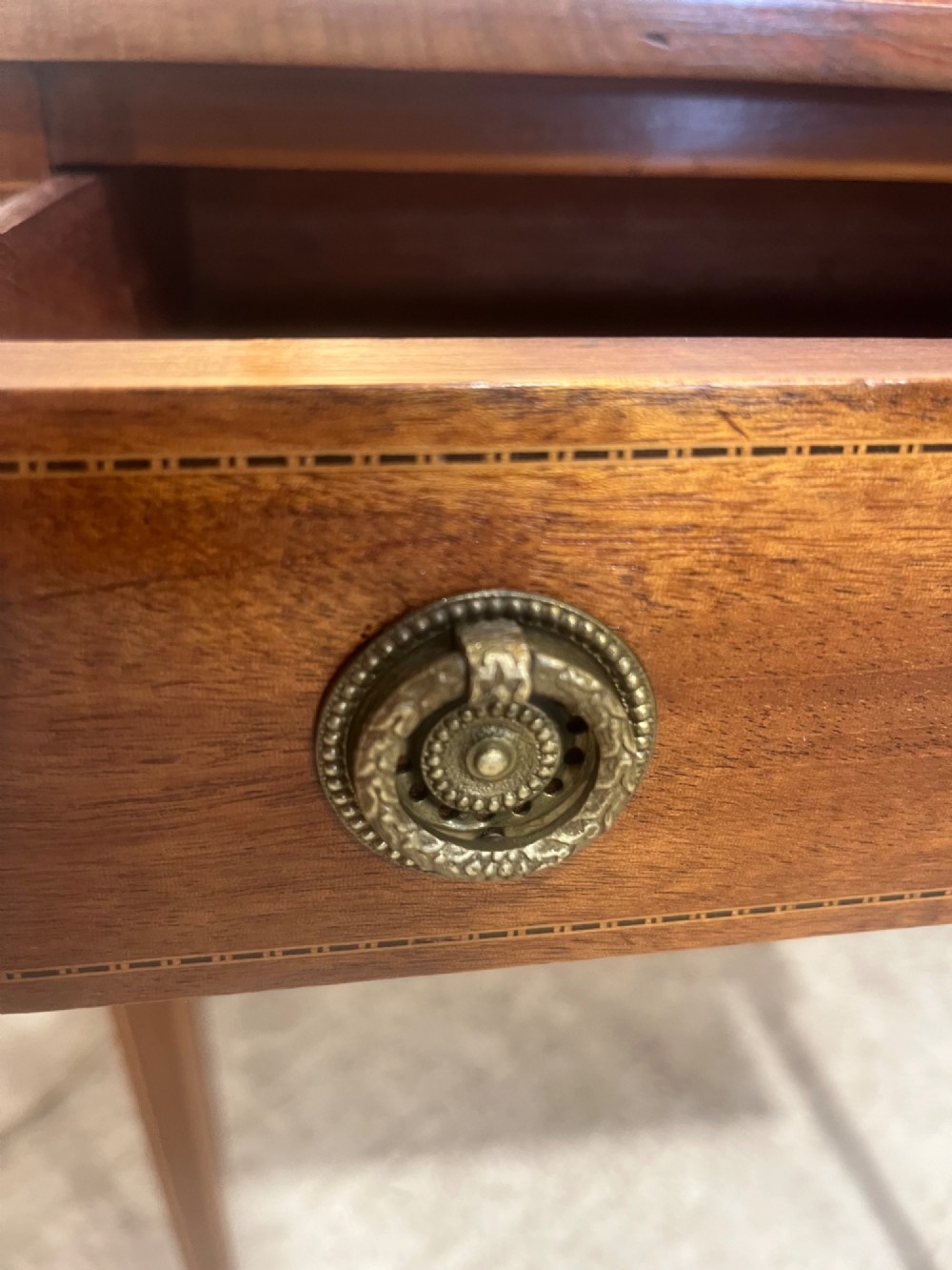 A 19th-century mahogany side table featuring two hinged drop leaves, a single frieze drawer with dual brass ring handles, boxwood line inlay, and four square tapered legs. View VII