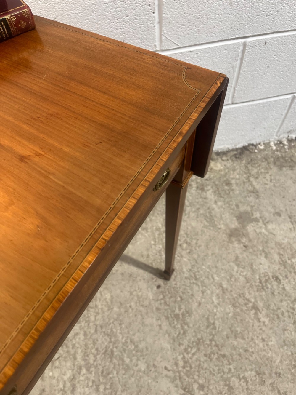 A 19th-century mahogany side table featuring two hinged drop leaves, a single frieze drawer with dual brass ring handles, boxwood line inlay, and four square tapered legs. View VIII