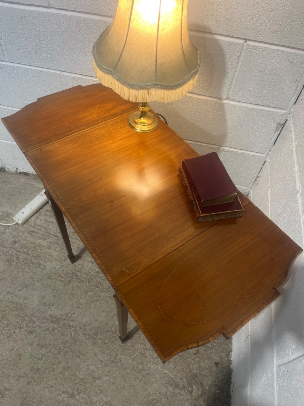 A 19th-century mahogany side table featuring two hinged drop leaves, a single frieze drawer with dual brass ring handles, boxwood line inlay, and four square tapered legs. View X