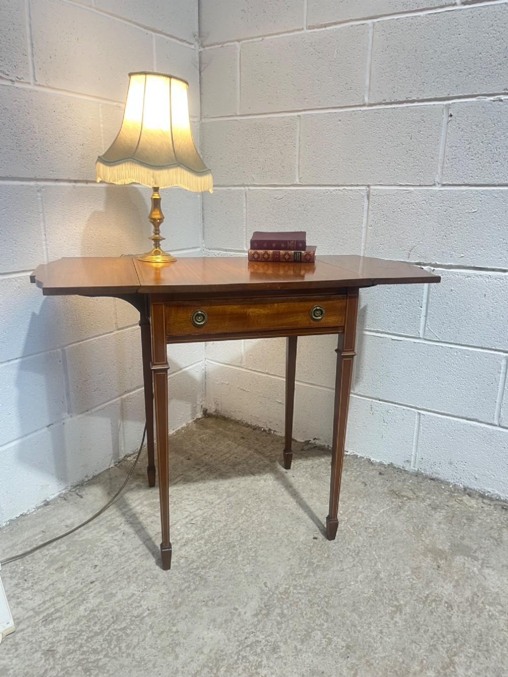 A 19th-century mahogany side table featuring two hinged drop leaves, a single frieze drawer with dual brass ring handles, boxwood line inlay, and four square tapered legs. View XV