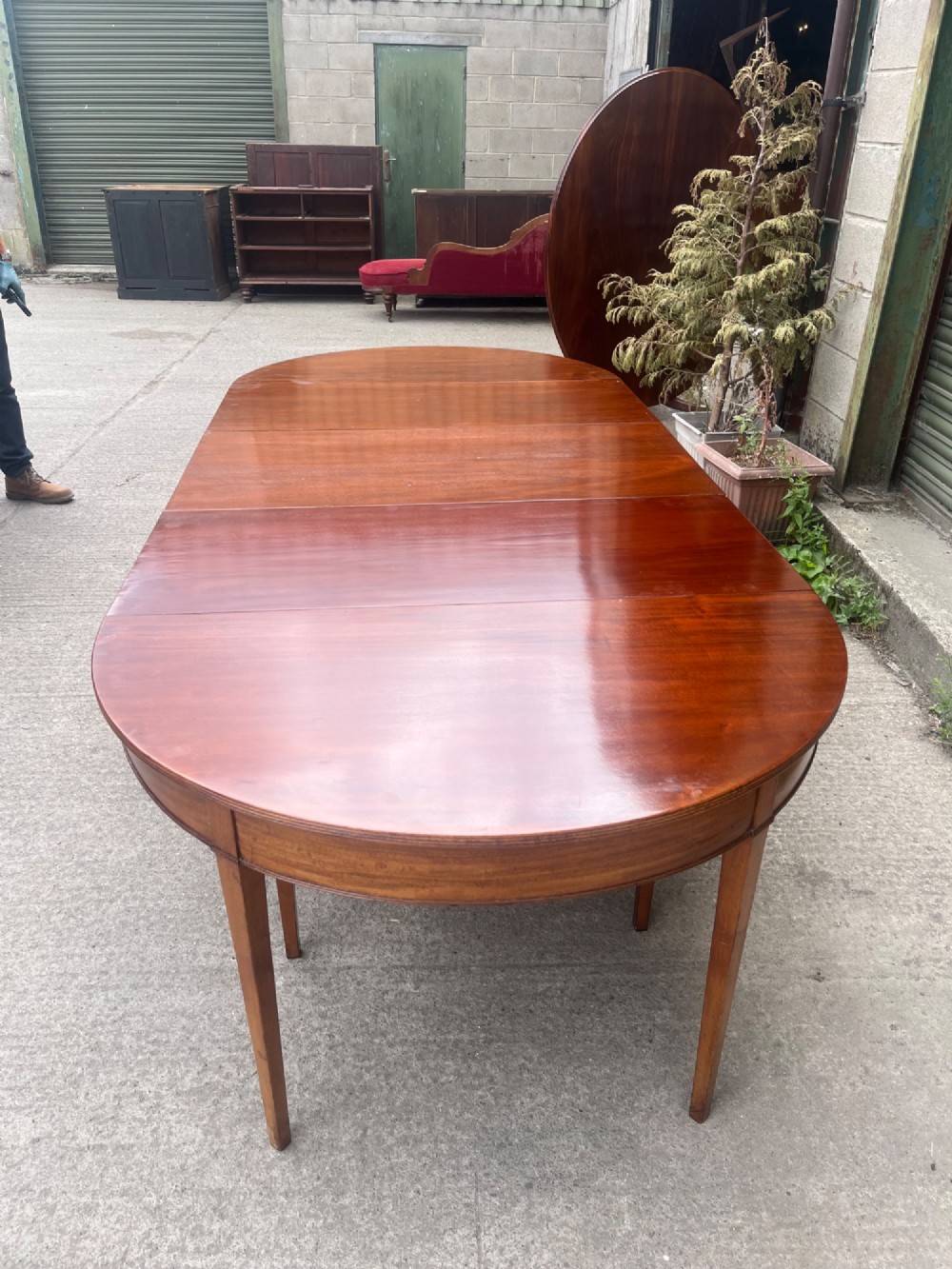 An extended 19th-century mahogany D-end dining table supported by multiple square tapered legs. View IV