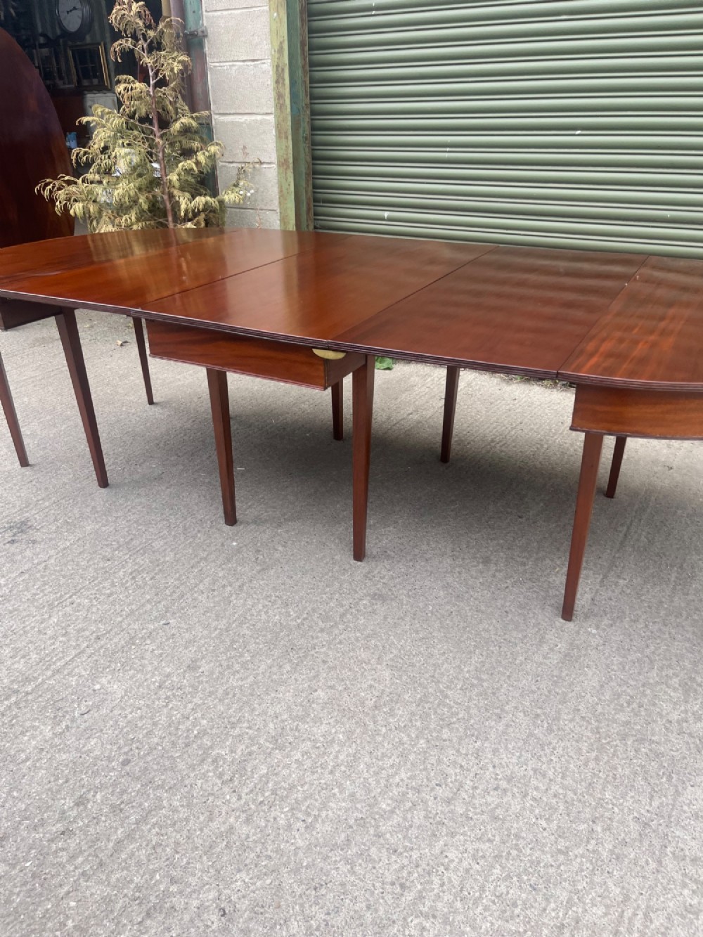 An extended 19th-century mahogany D-end dining table supported by multiple square tapered legs. View V