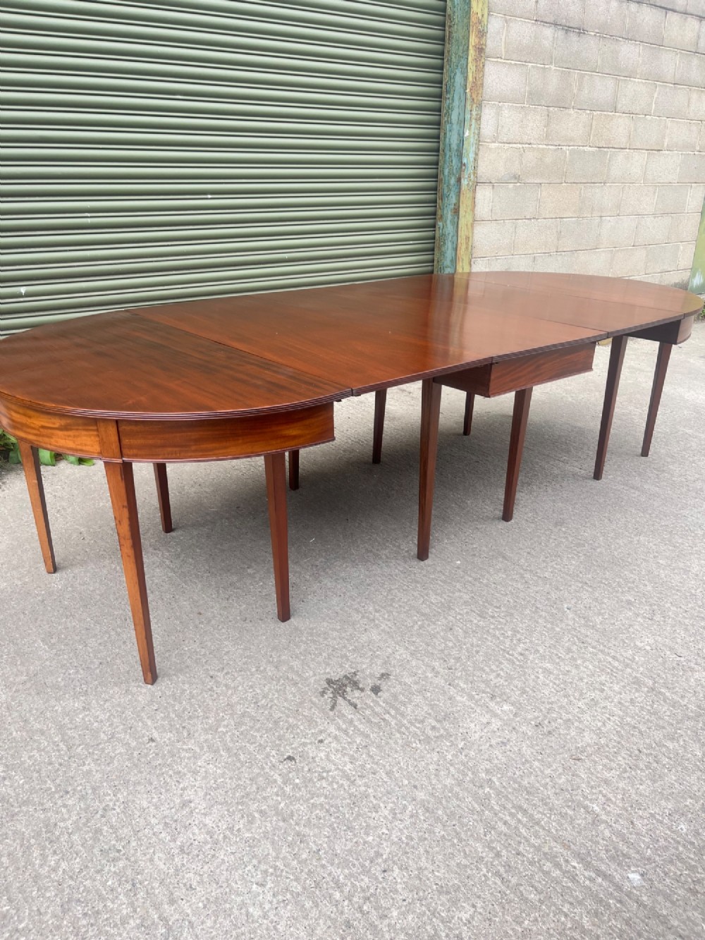 An extended 19th-century mahogany D-end dining table supported by multiple square tapered legs. View VI