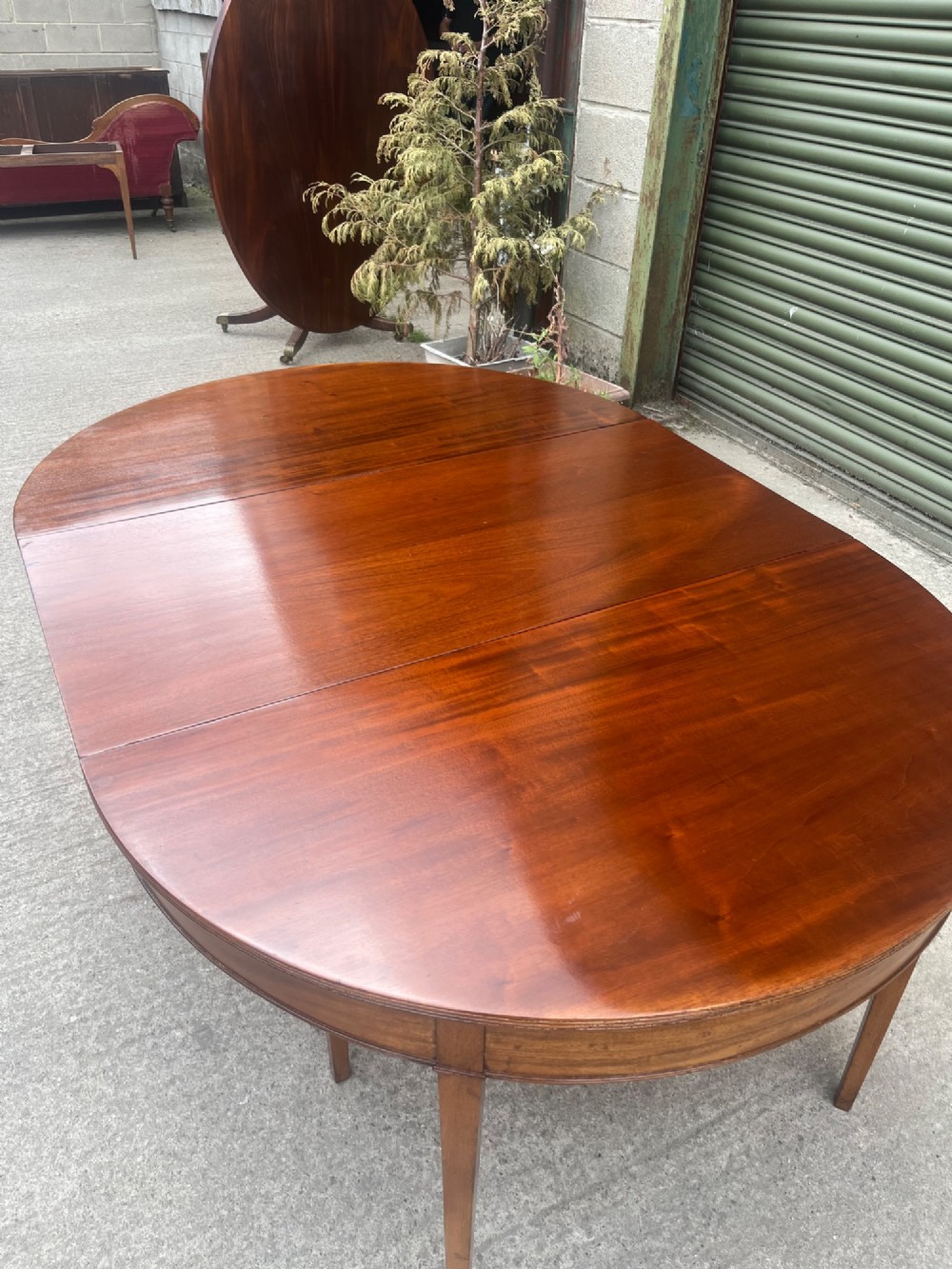 An extended 19th-century mahogany D-end dining table supported by multiple square tapered legs. View VIII
