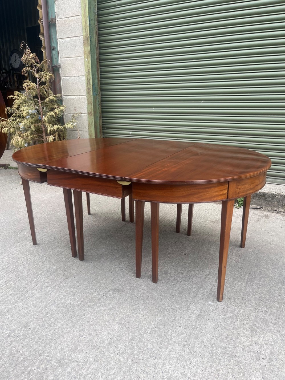 An extended 19th-century mahogany D-end dining table supported by multiple square tapered legs. View IX