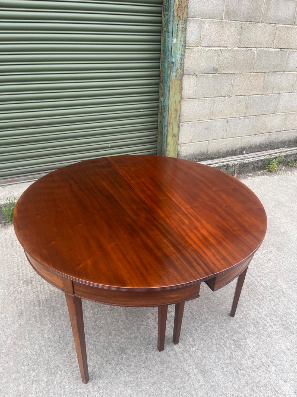 An extended 19th-century mahogany D-end dining table supported by multiple square tapered legs. View X