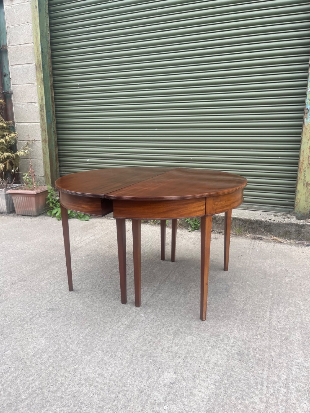 An extended 19th-century mahogany D-end dining table supported by multiple square tapered legs. View XI