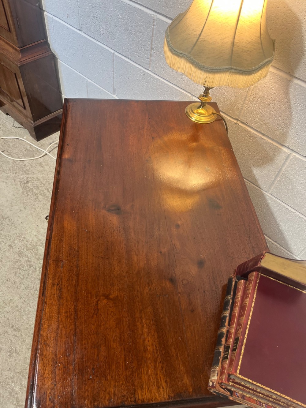A George III mahogany kneehole desk with a full-width upper drawer over six side drawers, a central recessed cupboard, brass swan-neck handles, and bracket feet. View VII