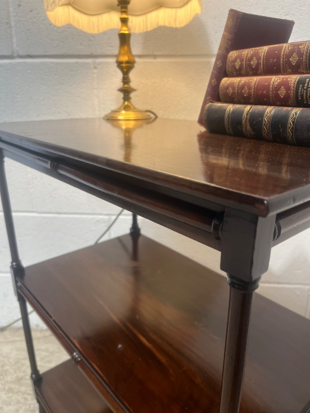 A nineteenth-century dark mahogany three-tier trolley with turned support columns and castor wheels. View V