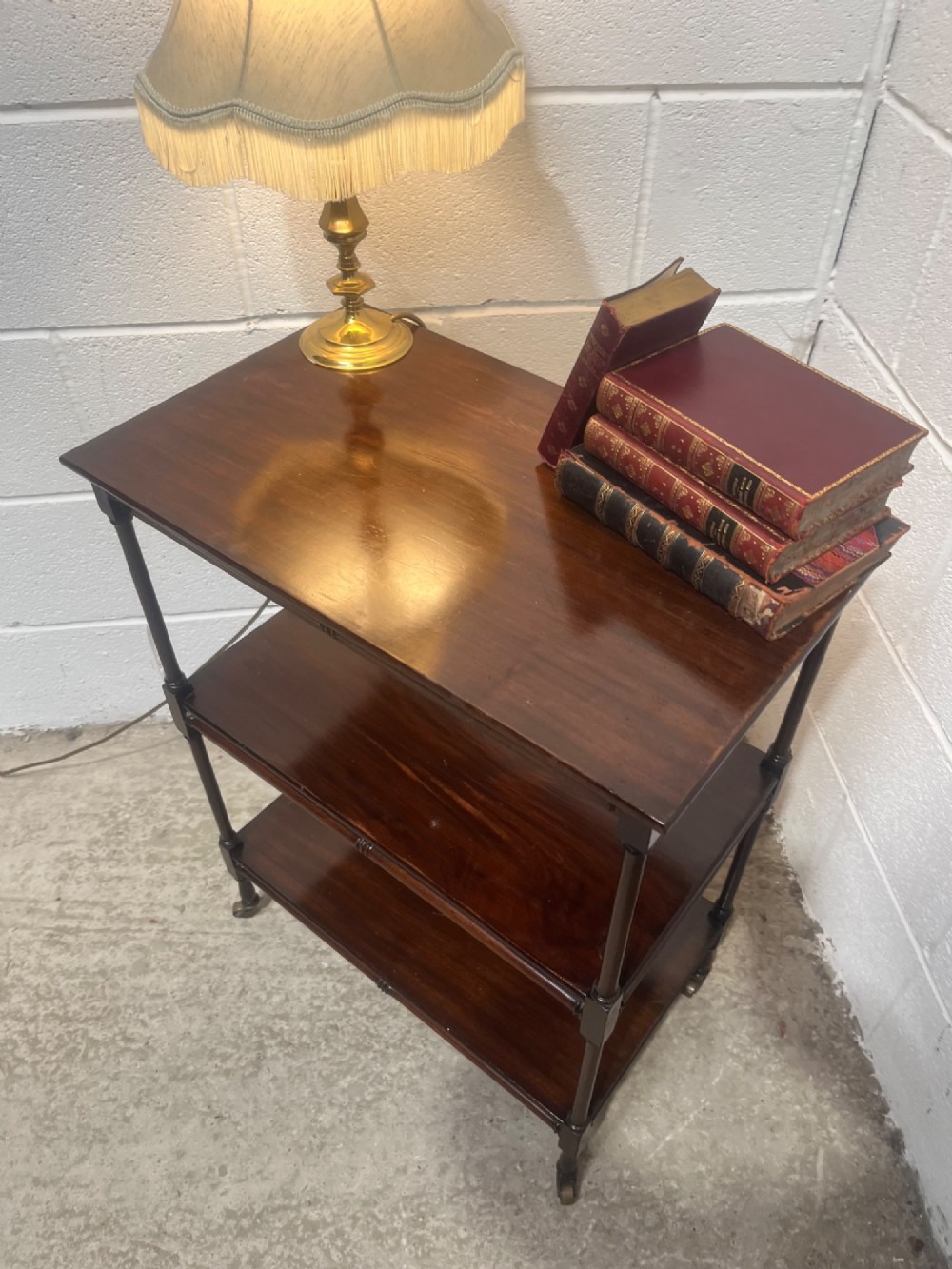 A nineteenth-century dark mahogany three-tier trolley with turned support columns and castor wheels. View X